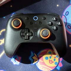 Tay cầm 8BitDo Ultimate 2 đặt trên bàn làm việc cùng dock sạc
