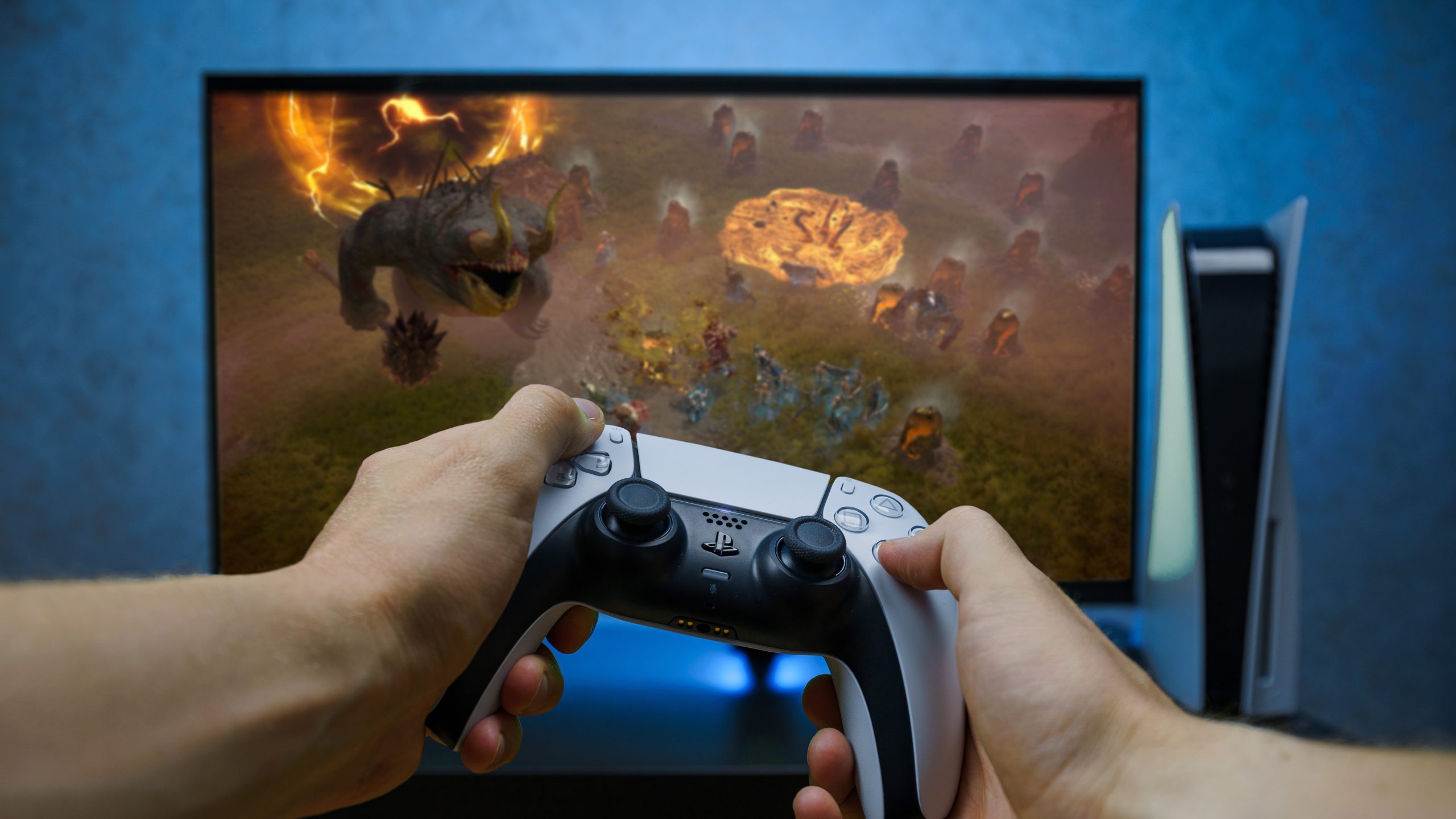 Tay cầm DualSense trước máy PlayStation 5 và màn hình
