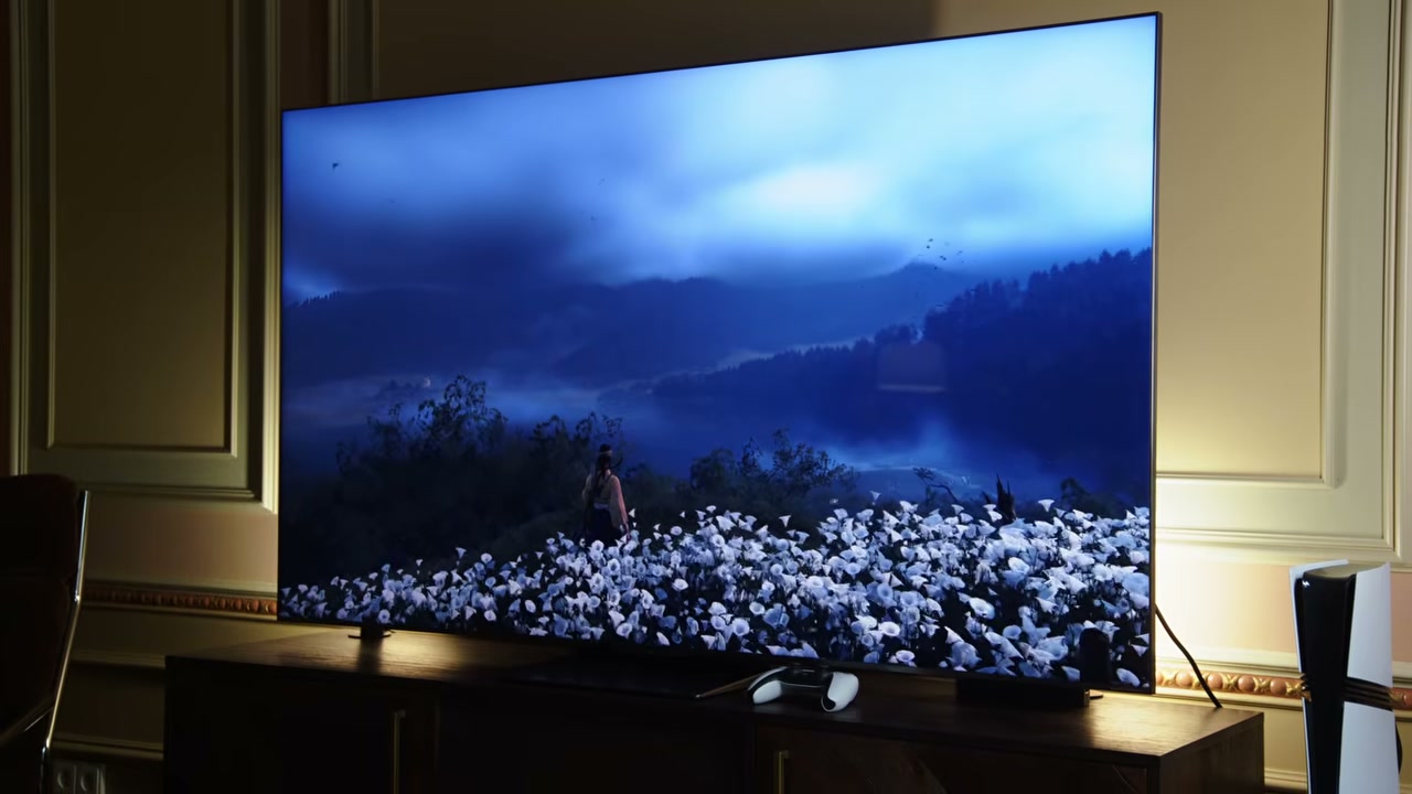 TV cỡ lớn trên kệ trong phòng khách, hiển thị cảnh game xanh tối