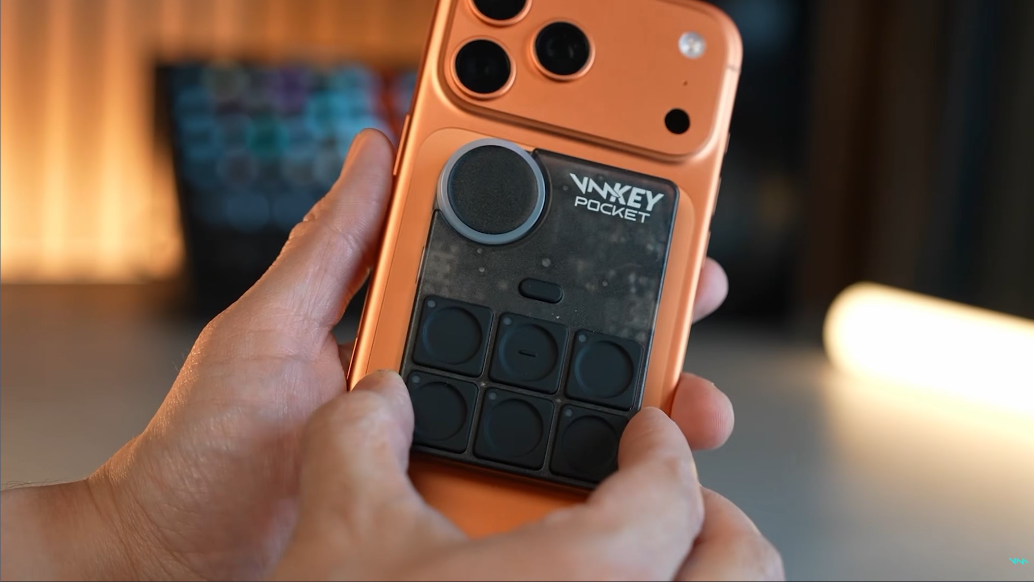 Voicemod Key Pocket gắn mặt sau điện thoại, với sáu phím điều khiển và núm xoay.