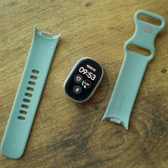 Vòng đeo Fitbit Edge và dây đeo rời đặt trên mặt bàn