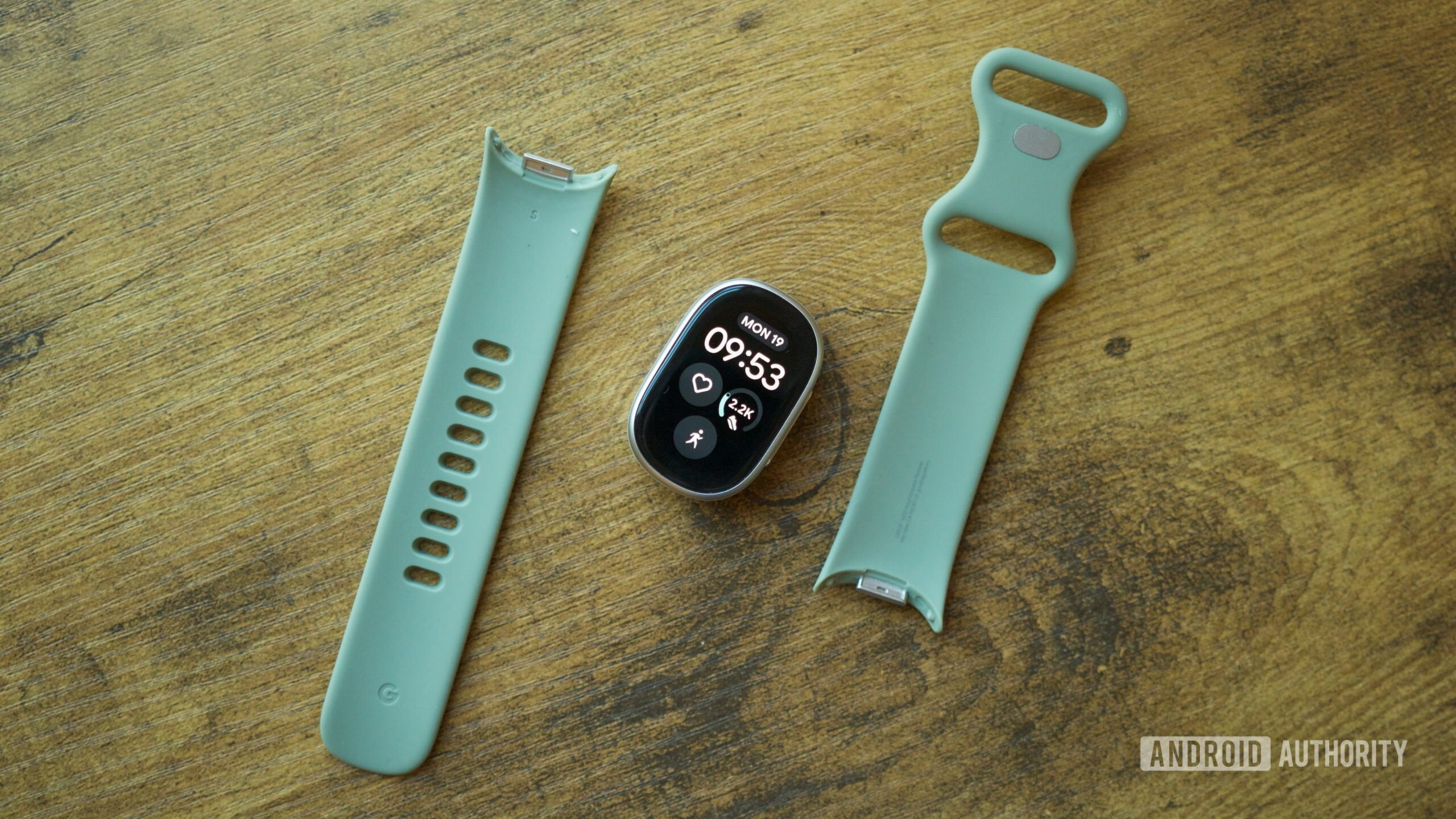 Vòng đeo Fitbit Edge và dây đeo rời đặt trên mặt bàn